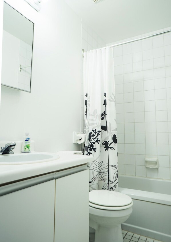 A bathroom with a toilet, sink, and shower curtain.