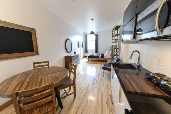 A modern kitchen with a central island, built-in appliances, and a dining area with a round table and chairs.