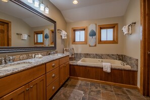 A bathroom with a large mirror, two sinks, a bathtub, wooden cabinets, and a tiled floor. - Top Property In Snowshoe 8 Br Nwr Rd 11 Luxury Home (Snowshoe)