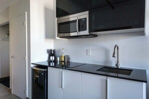 A modern kitchen with a dishwasher, a coffee machine, and a microwave.