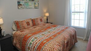 A bedroom with a large bed, a ceiling fan, a window with curtains, and wall art with motivational phrases. - Terra Verde 70 (Kissimmee)