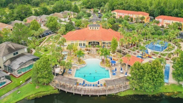 A resort with a central swimming pool, multiple guest villas, and a surrounding natural landscape. - Terra Verde 70 (Kissimmee)