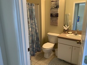Une salle de bain avec des toilettes, un lavabo et un rideau de douche.