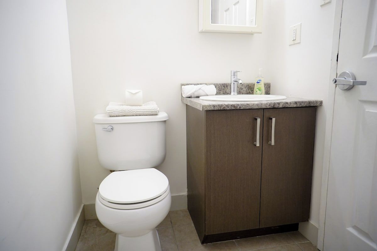 A standard bathroom with a toilet, a sink, and a cabinet.