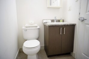 A standard bathroom with a toilet, a sink, and a cabinet.
