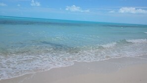 A beach with clear turquoise water and gentle waves.