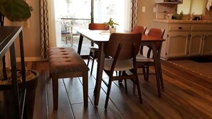 Ein Essbereich mit Holztisch und Stühlen, einer Bank und einem Blumentopf.