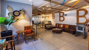 A modern interior with a wooden ceiling, a large 'B' wall decoration, and a seating area with a coffee table. - B&B Hotels Rio de Janeiro Norte (Rio de Janeiro)