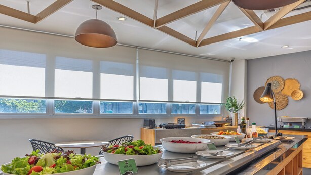 A buffet setup with various food items, a salad bowl, and a sign indicating a mix of salads. - B&B Hotels Rio de Janeiro Norte (Rio de Janeiro)