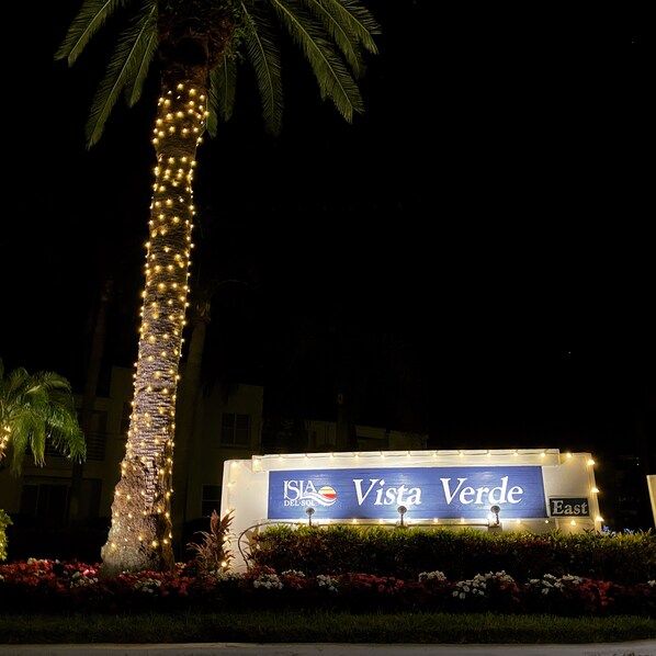 A sign for Vista Verde hotel with a palm tree wrapped in lights.