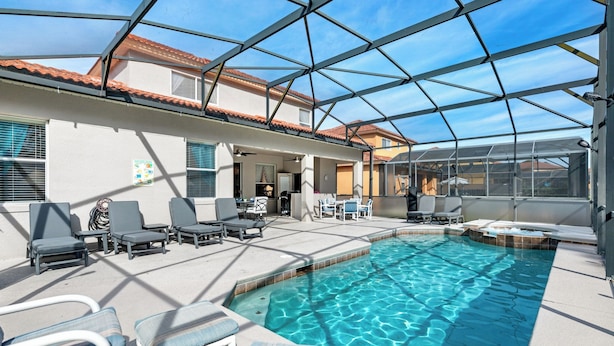 An indoor swimming pool with lounge chairs and a covered patio area. - Gorgeous Davenport 5 Bed Villa With Pool Hot Tub (Davenport)