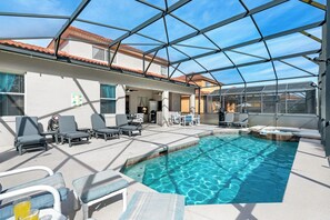 Une piscine intérieure dotée de chaises longues et d’un patio couvert.