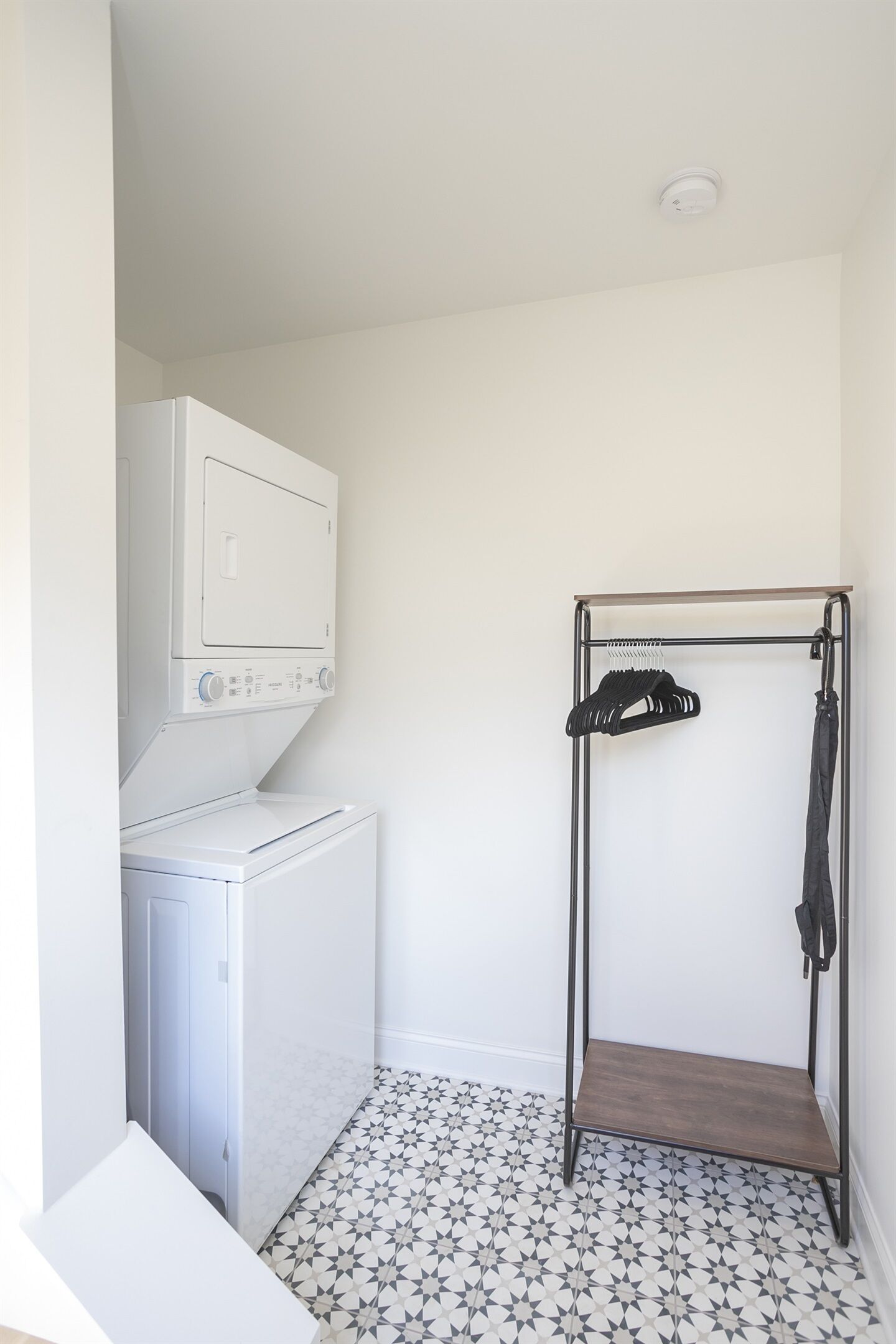 Un espace buanderie équipé d’un lave-linge, d’un sèche-linge et d’un étendoir.
