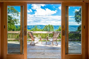 Relax on the wooden deck with mountain views framed by sliding glass doors. - 3BR cabin w/ scenic deck and pet-friendly (Great Cacapon)