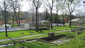 Un parc avec une piscine, des bancs et un petit bâtiment.