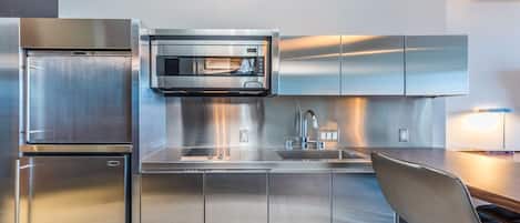 Une cuisine moderne équipée d’appareils électroménagers en acier inoxydable, d’un four à micro-ondes encastré et d’un évier.