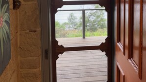 A wooden door with a decorative glass panel and a view of a green landscape. - Historic Georgian Stone Built Cottage (Saint Albans)