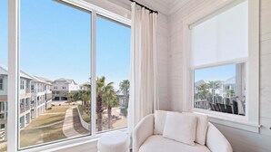 Una habitación moderna con un gran ventanal que ofrece vistas a una zona residencial y a una piscina.