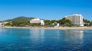 A coastal hotel with a beach view, a mountain in the background, and clear blue waters. - Canyamel Garden Apartments (Capdepera)