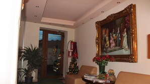 Eine Hotelhalle mit einem großen Gemälde, einem Weihnachtsbaum und einer Zimmerpflanze.