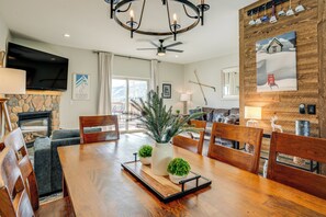 Enjoy meals in the dining area with a large table and comfortable seating, a flat-screen TV, and a cozy fireplace.
