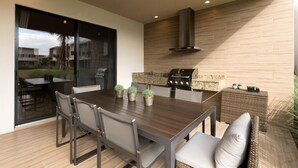 A modern kitchen with a large dining table, chairs, and a built-in grill. - 4 B/R Charming Townhome with Free WiFi & Parking, close to Disney (Kissimmee)