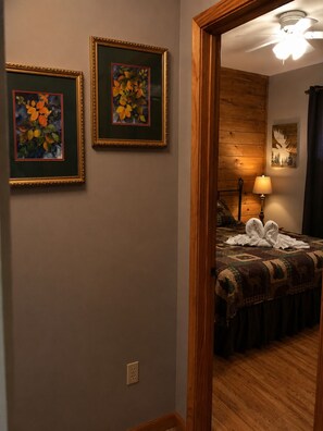 Ein Hotelzimmer mit einem Bett, einer Lampe und zwei gerahmten Bildern an der Wand.