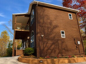 A two-story building with a balcony on the ground floor and a small window on the upper floor. - Gatlinburg, Autumn Leaves, Great Mountain Views, Hot Tub, Pool Table, Fireplace. (Gatlinburg)