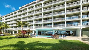 A multi-story hotel with balconies, a swimming pool, and a covered outdoor seating area. - Lahaina Shores Beach Resort Studio (Lahaina)