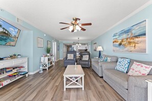 A living room with a ceiling fan, a sofa, a coffee table, and a TV. - Upgraded Unit good for Mobility Issues - SSV0606 - Ocean Front Condo (North Myrtle Beach)