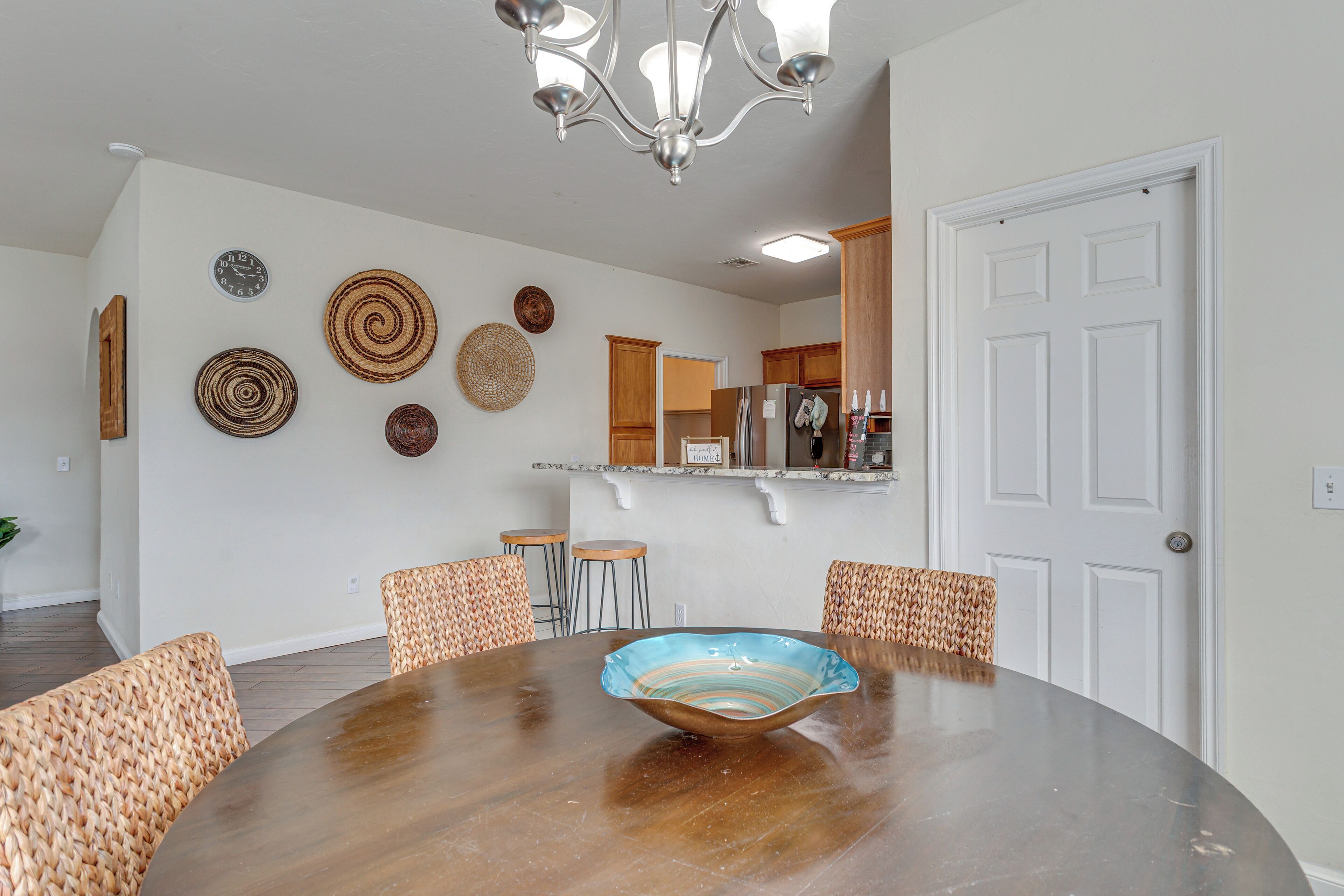 Un coin repas avec une table ronde, des chaises en osier et un bol décoratif.