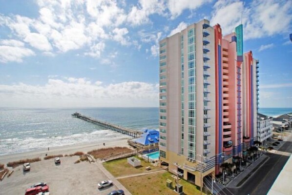 Ein Hochhaus-Hotel mit mehreren Balkonen mit Blick auf Strand und Meer.