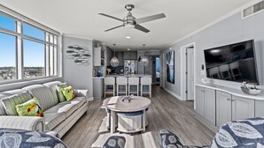 A modern living room with a sofa, a round table, and a TV.