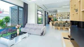 Ein modernes Wohnzimmer mit einer Couch, einem Couchtisch und einem Essbereich mit Stühlen und einem Tisch.