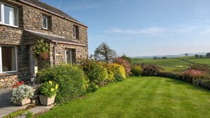 A stone house with a well-maintained lawn and a view of the countryside. - High Butterbent Cottage -  Rural cottage that sleeps 6 guests  in 3 bedrooms (Kendal)