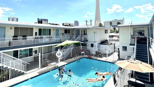 A hotel pool area with a view of a tall tower in the background. - Condo,2Bedrooms,Sale,Strip,BOOK,Las Vegas,LVCC,wifi,SALE,pool,SemaShow,Labor Day (las vegas)