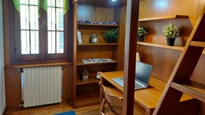 Een houten kamer met een bureau, planken en een radiator.