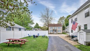 Ein Garten mit Picknicktisch, Stühlen und einer kleinen Gartenhütte.