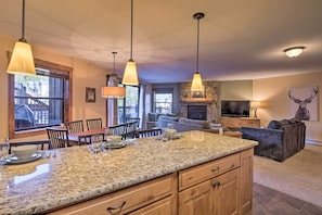 Enjoy cooking in this well-equipped kitchen with a granite countertop and wooden cabinetry.