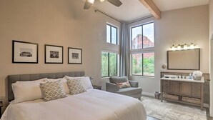 Une chambre avec un grand lit, une coiffeuse avec un miroir et des tableaux encadrés accrochés au mur.