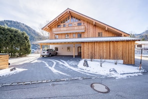 Un edificio in legno con un portico e un'auto parcheggiata di fronte.