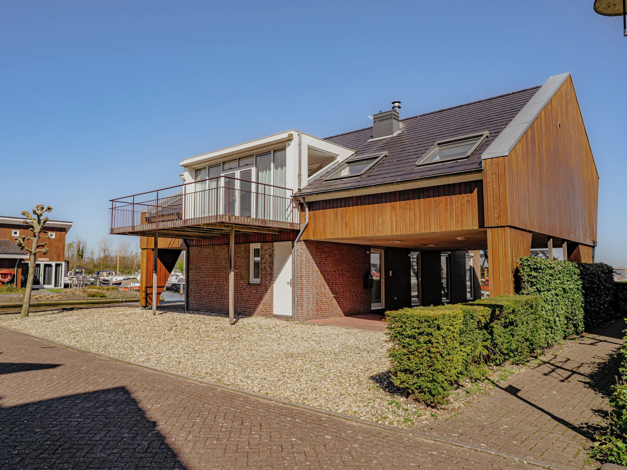 A modern two-story house with a balcony, a garage, and a driveway.
