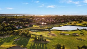A golf course with sand bunkers, a pond, and a residential area in the background. - Albarella Maisonette S3M 3, Isola di Albarella, Italy (Isola di Albarella)