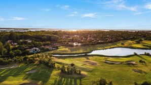 A golf course with sand bunkers, a pond, and a residential area in the background. - Albarella Maisonette S3M 1, Isola di Albarella, Italy (Isola di Albarella)