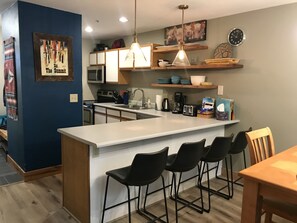 Enjoy cooking and dining in this kitchen with a central island, microwave, stove, and coffee maker.