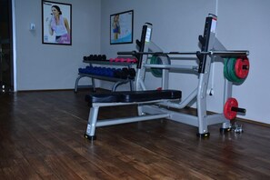 Una palestra con bilanciere, manubri e pesi.