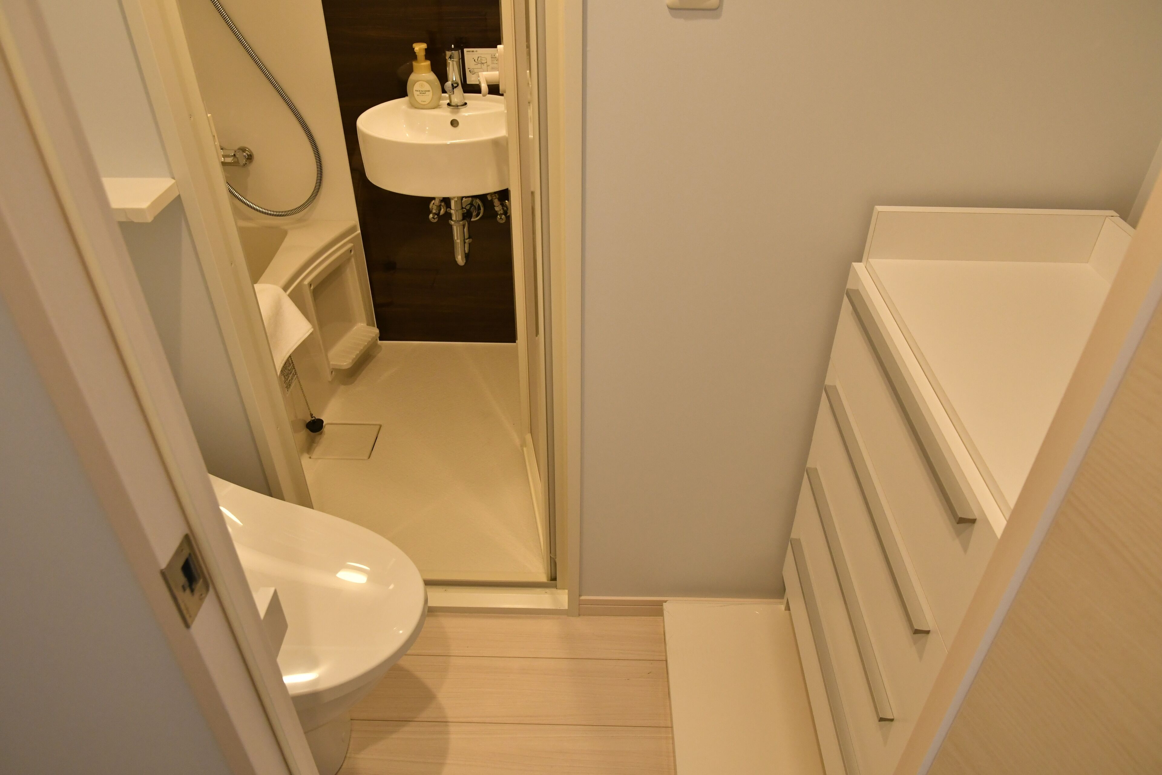 A small, modern bathroom with a toilet, sink, and shower.