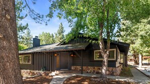 Une cabane rustique avec des fondations en pierre, un revêtement en bois et un toit en pente.