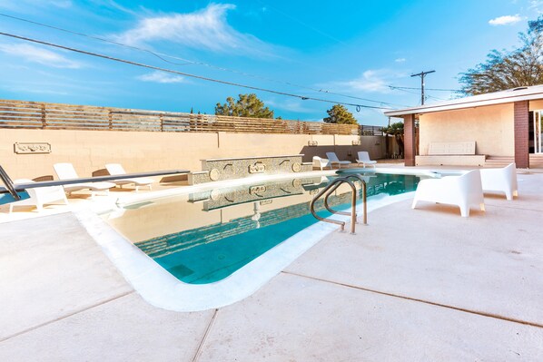 Relax by the pool surrounded by comfortable lounge chairs.