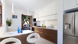 Una cocina moderna con una isla central, electrodomésticos de acero inoxidable y armarios de madera.